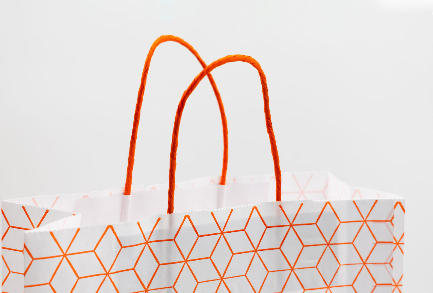 Pack de 25 Bolsas de Papel Kraft Reciclado con Asas Trenzadas y Estampado Geométrico en Naranja