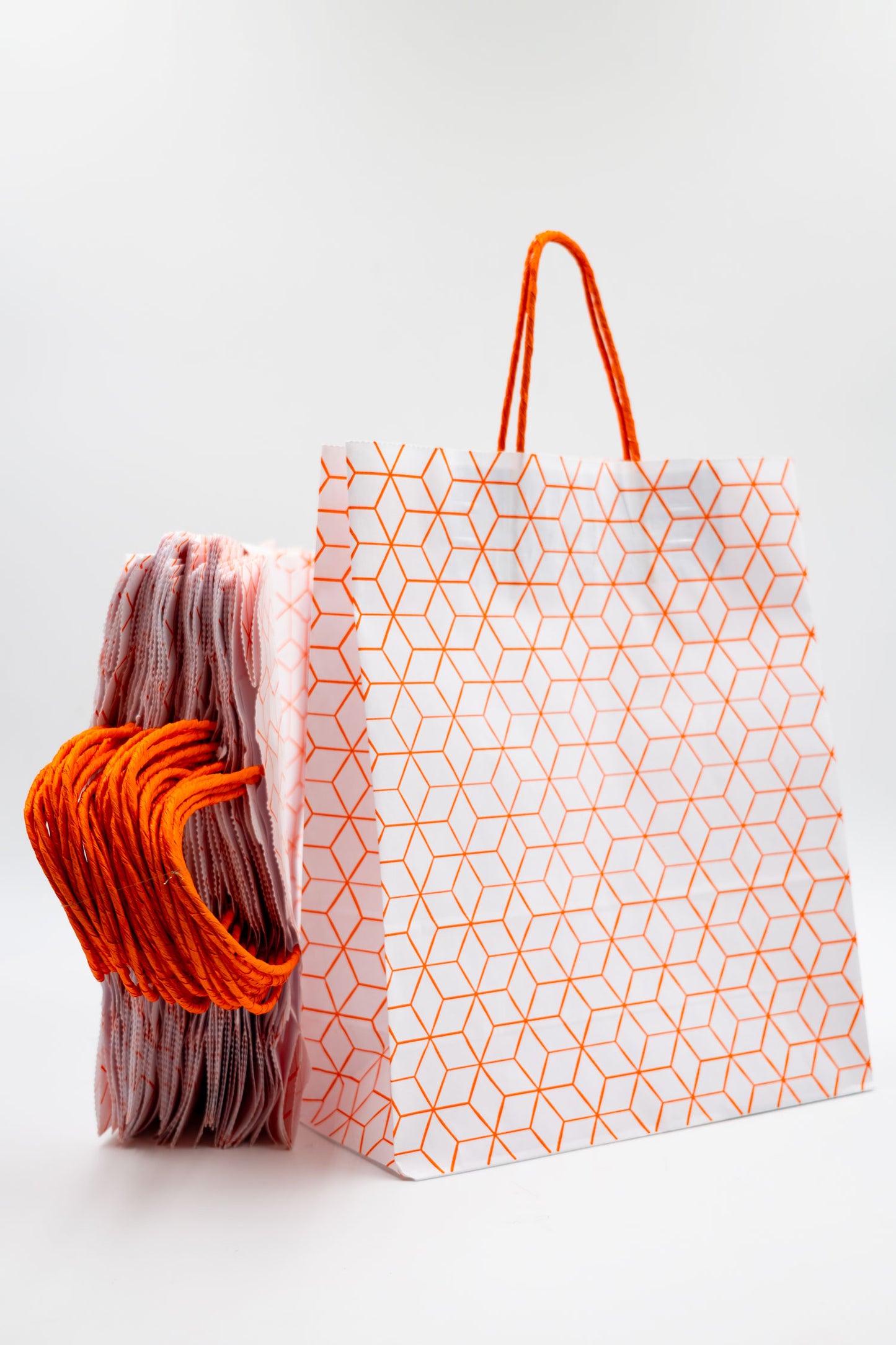 Pack de 25 Bolsas de Papel Kraft Reciclado con Asas Trenzadas y Estampado Geométrico en Naranja